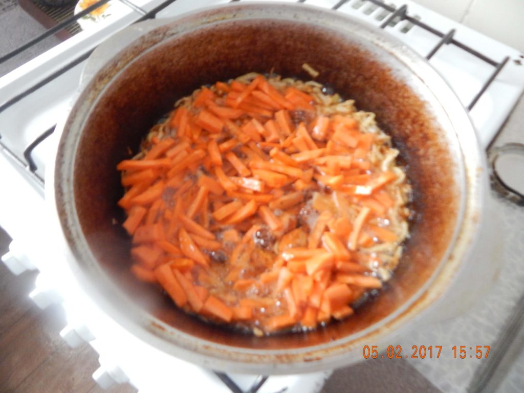 На фото: обжарка лука и моркови для приготовления плова