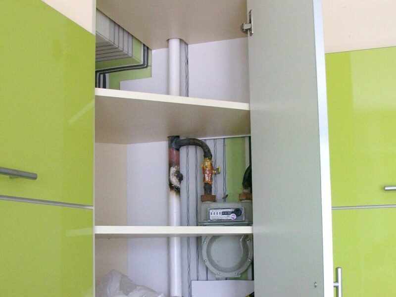 На фото: навесной шкаф для маскировки газовых труб на кухне.